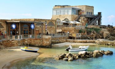 Experience the serene beauty of Caesarea with Lionsgate Travel, featuring ancient ruins juxtaposed against the tranquil Mediterranean Sea.