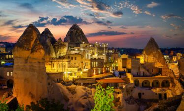 A panoramic view of Göreme's historic cave formations, carved into fairy chimneys under a clear blue sky, inviting exploration and adventure.