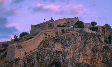 Explore the charming streets and historic fortifications of Nafplio, Greece with Lionsgate Travel, set against the backdrop of the Aegean Sea.