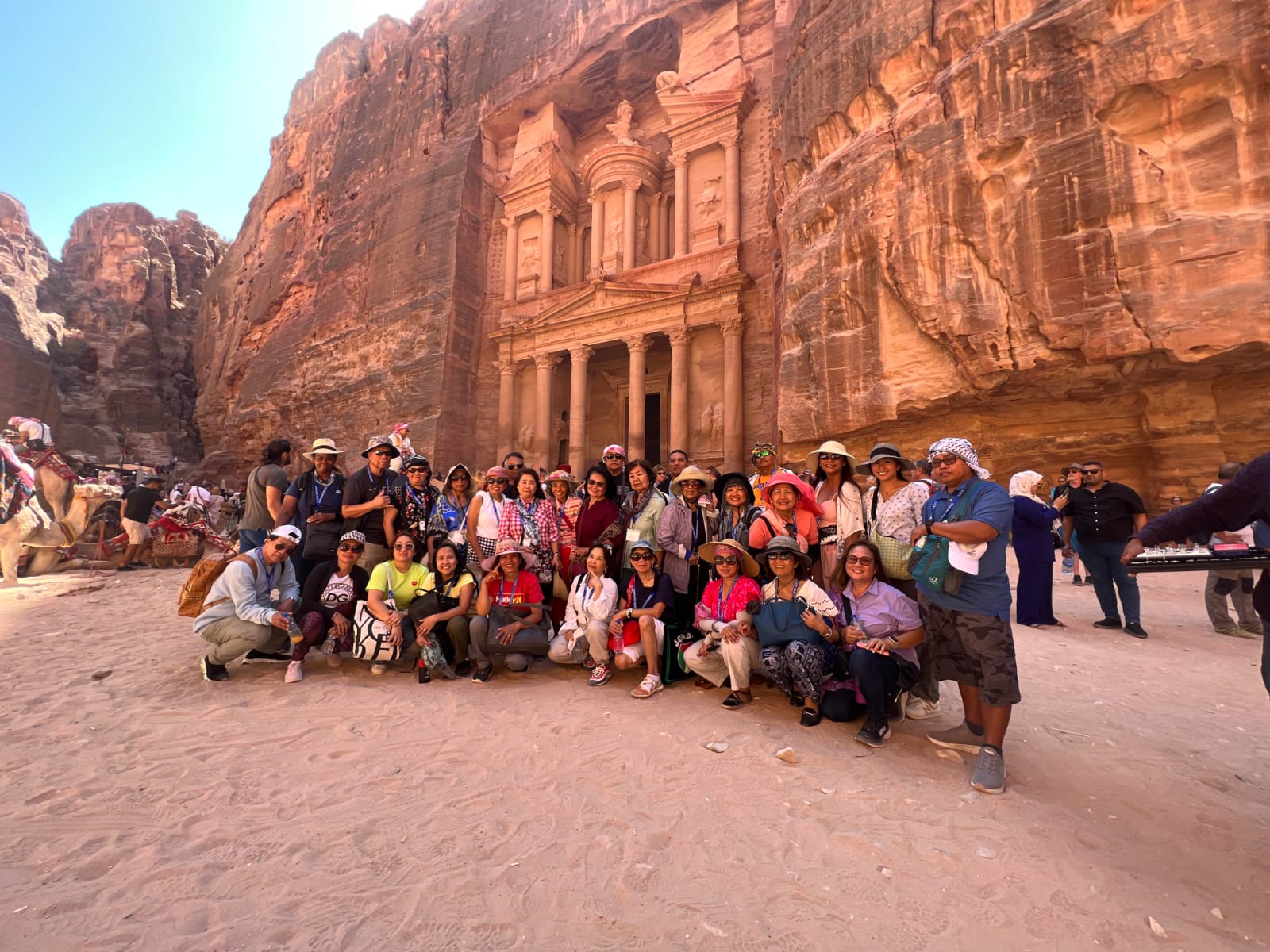 A group of happy travelers posing in front of a historic landmark during a Lionsgate Travel tour.