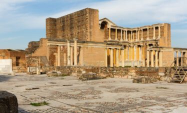 Ruins of the ancient city of Sardis, showcasing the Temple of Artemis with massive columns standing against a clear sky.