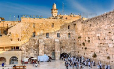 Visitors praying at the Western Wall in Jerusalem, a sacred site filled with historical and spiritual significance.