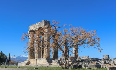 Scenic view of Corinth, Greece, showcasing the historic ruins and vibrant modern life, blending ancient heritage with contemporary culture.